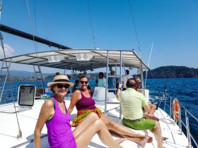 A cheerful group enjoys a sunny day on a boat, relaxing and celebrating together — perfect for memorable outings on the water.