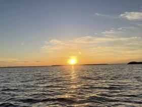 A stunning sunset over tranquil waters, capturing the serene beauty of the evening sky — perfect for romantic boat outings or peaceful reflections.