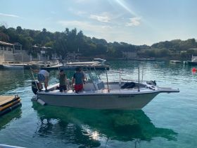 A group of friends prepares for a fishing adventure on a boat in a serene harbor, showcasing the perfect setting for a day on the water.