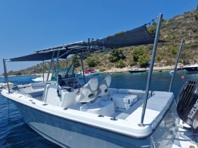 A sleek center console boat docked in calm waters, showcasing its spacious design and modern features, perfect for fishing or leisure outings.
