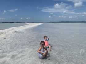 Two children enjoy a sunny day on a sandbar, showcasing the joy of family beach outings and playful adventures in the water.