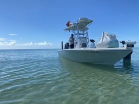 Two individuals aboard a boat in calm waters, enjoying a day on the water — perfect for fishing or leisure activities.