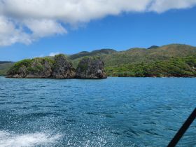 A stunning view of rocky islands surrounded by vibrant blue waters, showcasing the natural beauty of the coastline — perfect for eco tours and sightseeing adventures.