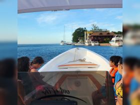 A family enjoys a scenic boat ride, capturing the essence of adventure on the water with beautiful views of the shoreline and nearby boats.