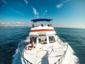 A group enjoys a sunny day aboard a boat, capturing the essence of relaxation on the water with stunning views in the background.