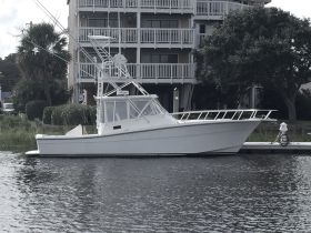 A sleek fishing boat docked by the waterfront, showcasing its elegant design and structure, perfect for fishing enthusiasts.