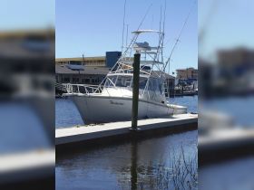 The Barbarino, a fishing boat, is docked peacefully at the marina, showcasing its sleek design against a clear blue sky.