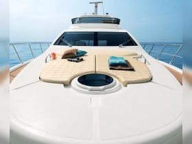 A luxurious lounge area on a yacht featuring comfortable seating and towels, perfect for sunbathing and relaxation while enjoying the open water.