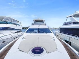 A stunning view of a yacht docked among other vessels, showcasing its sleek design and luxurious features under a clear blue sky.