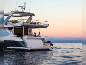 A group enjoys a sunset on a yacht, with one person diving into the serene waters — a perfect moment for summer adventures and aquatic fun.