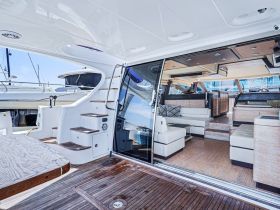 A spacious and elegantly designed interior of a yacht featuring comfortable seating and a well-equipped helm, perfect for relaxing or navigating on the water.