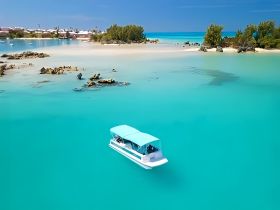 A stunning aerial view of a boat cruising through crystal-clear turquoise waters, showcasing the beauty of the surrounding landscape and inviting exploration.