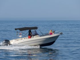 A couple enjoys a sunny day on the water aboard a sleek boat, capturing the essence of a perfect day out on the sea.