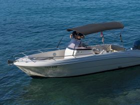 A sleek speedboat navigates through clear waters, showcasing its stylish design and perfect for thrilling outings on the sea.