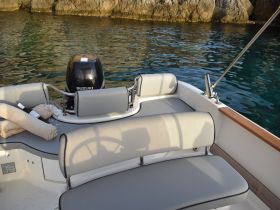 A cozy interior view of a boat featuring comfortable seating and a Suzuki outboard motor, perfect for relaxing on the water.