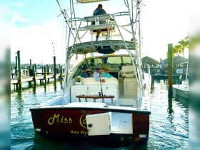 A group of friends enjoys a moment aboard the 'Miss C' in Key West, showcasing the vibrant atmosphere of a boating adventure.