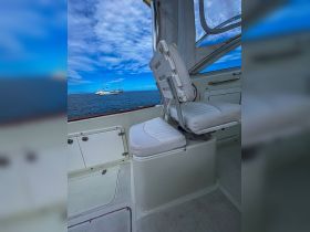 Interior view of a boat's helm seating area, showcasing comfortable seating and a clear view of the water, perfect for navigating the seas.