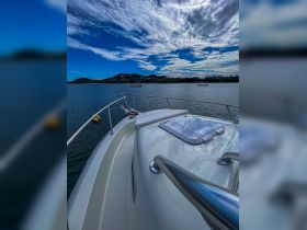 A stunning view of a boat's exterior with a picturesque backdrop of hills and a vibrant sky, perfect for showcasing marine adventures.