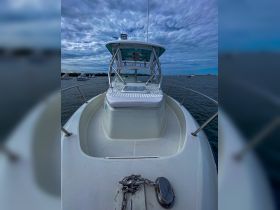 A clear view of the front deck of a boat, showcasing its sleek design and structure against a cloudy sky — perfect for showcasing vessel features.