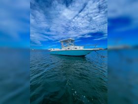A sleek speedboat glides through clear waters under a vibrant sky, showcasing its design and elegance — perfect for thrilling adventures on the water.