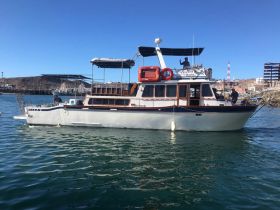 A classic yacht is seen underway in calm waters, showcasing its elegant design and structure, perfect for leisurely cruises.