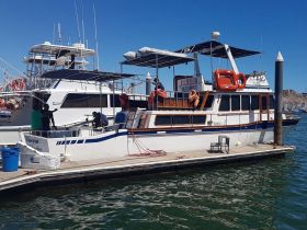 A docked yacht with crew members preparing for departure, showcasing the boat's exterior and vibrant marina setting.