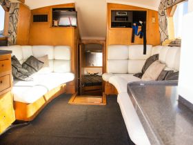 Interior view of a cozy boat cabin featuring comfortable seating and a well-organized space, perfect for relaxing during a day on the water.