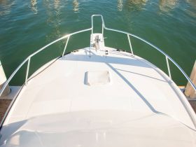 A clear view of the front deck of a yacht docked at the marina, showcasing its sleek design and tranquil waters.