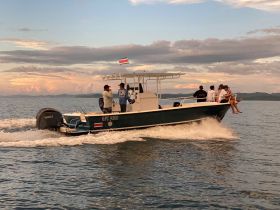A lively group enjoys a boat ride, capturing the essence of adventure on the water with stunning sunset views in the background.
