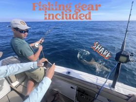 A young angler reels in a shark while fishing, showcasing the excitement of on-water adventures. Fishing gear is included for an unforgettable experience.