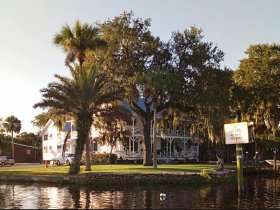 A scenic view of a waterfront property with palm trees and a sign, but the image lacks clarity and focus.
