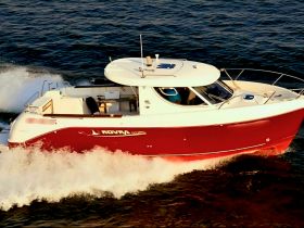 A sleek speedboat cuts through the waves, showcasing its vibrant red hull and modern design — perfect for thrilling adventures on the water.