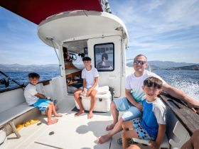 A joyful family enjoys their time aboard a boat, with children smiling and having fun — perfect for creating lasting memories on the water.