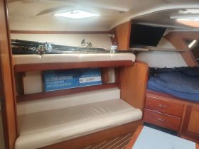 Interior view of a boat cabin featuring seating and fishing gear, ideal for anglers looking to enjoy a comfortable fishing experience.