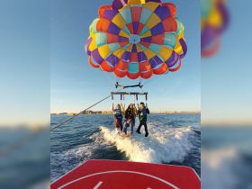 A thrilling parasailing adventure with a group enjoying the stunning views over the water — perfect for adrenaline seekers and family fun.