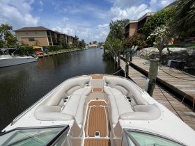 A spacious interior view of a boat showcasing comfortable seating and helm area, perfect for relaxing on the water.