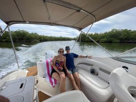 A couple enjoys a relaxing moment on a boat, surrounded by lush greenery and calm waters — perfect for a scenic getaway.