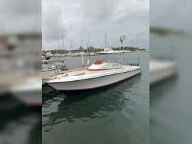 A sleek speedboat docked in a marina, surrounded by other vessels, showcasing its design and readiness for adventure on the water.