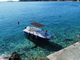 A picturesque view of a boat docked in crystal-clear waters, showcasing the vibrant marine environment — perfect for a day of exploration or relaxation.