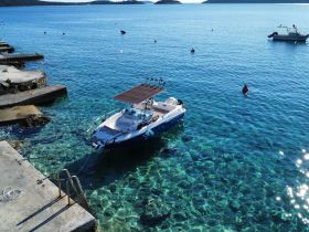 A picturesque view of a speedboat docked in crystal-clear waters, showcasing the vibrant marine environment — perfect for a day of exploration or relaxation.