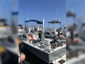 A fishing boat named 'Fresh Catch' is docked, showcasing its fishing gear and equipment, perfect for a day on the water.