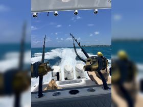 A thrilling fishing adventure underway, showcasing the boat's powerful engines and fishing gear as it cuts through the vibrant blue waters.