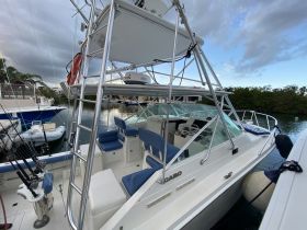 Interior view of a well-equipped fishing boat featuring comfortable seating and a modern helm, perfect for a day on the water.