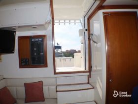 Interior view of a boat's helm area featuring a console and seating, showcasing the comfortable and functional design ideal for navigation and relaxation.