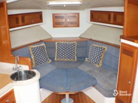 Cozy interior seating area of a boat, featuring plush cushions and a functional layout, perfect for relaxing during trips on the water.