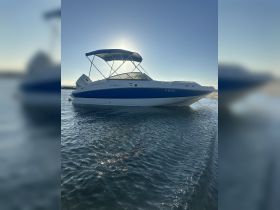 A sleek speedboat is docked in calm waters, showcasing its elegant design against a clear sky — perfect for a day of adventure on the water.