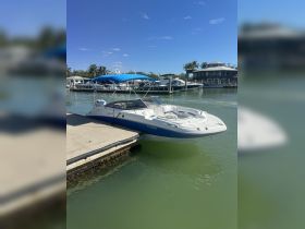 A sleek speedboat docked at a marina, showcasing its stylish design against a clear blue sky — perfect for water adventures.