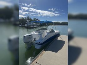 A sleek speedboat docked at the marina, showcasing its stylish design and ready for a day on the water.