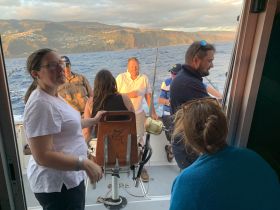 A lively group enjoys a fishing trip on the ocean, capturing the excitement of the experience against a stunning coastal backdrop.
