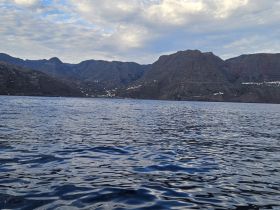 A stunning view of the mountainous coastline reflecting on the calm waters, perfect for showcasing the natural beauty of the region.